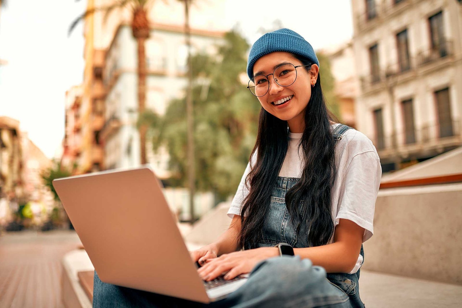 Careers at Medcity International Academy | Jobs in Kerala 2 A student using a laptop outdoors while preparing for study abroad applications through Medcity International Academy, representing international education, online learning, university admissions, and student visa preparation.